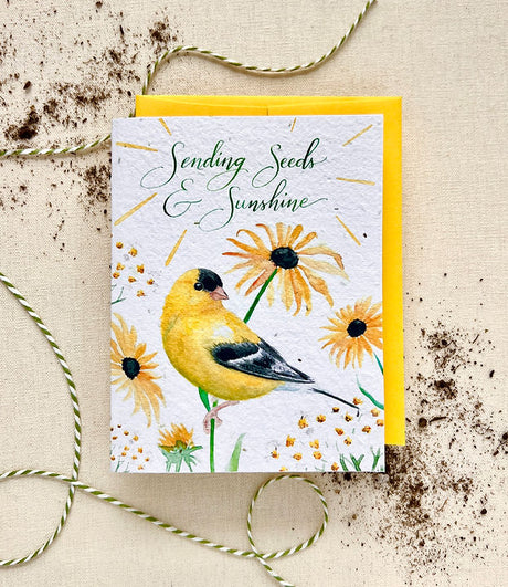 Greeting card with a yellow bird (goldfinch) and sunflowers on a textured beige background